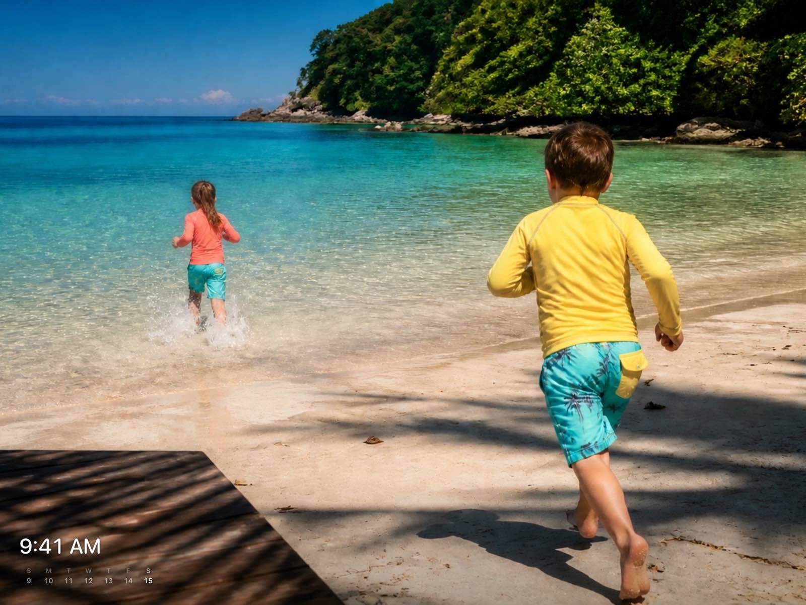 A photo of children running on a beach, with the time and a week calendar tucked into the lower corner.